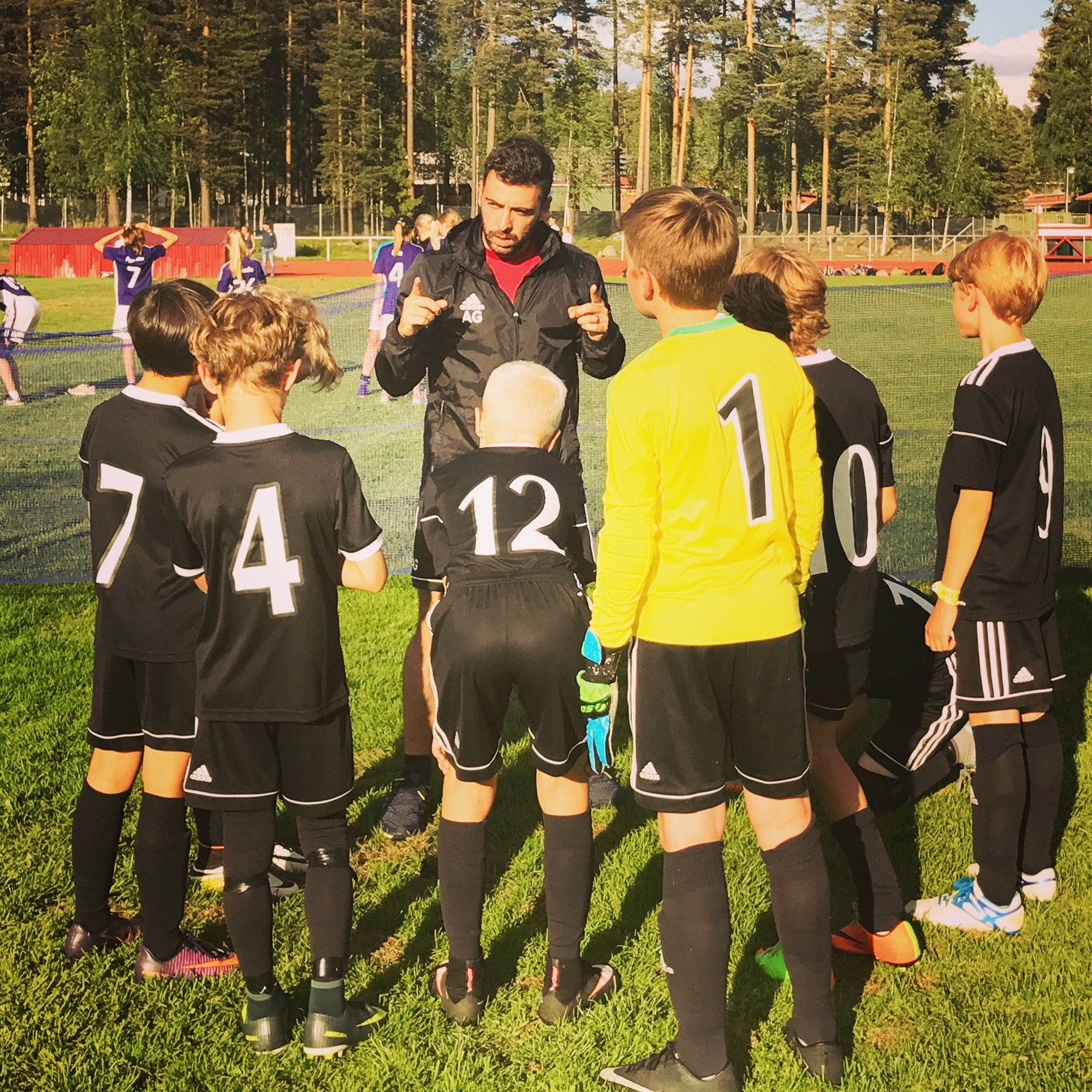 A youth football group listening to a coach